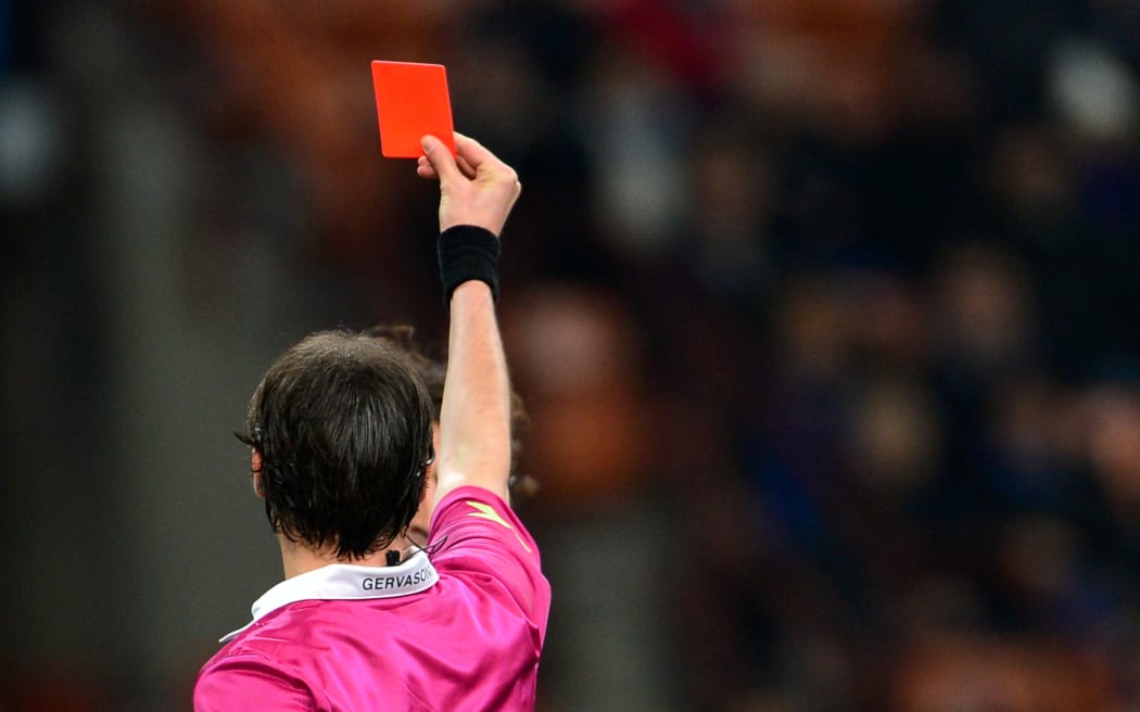 Atalanta's Italian midfielder Cristian Raimondi (hidden, background) receives a yellow card from the referee Andrea Gervasoni (front) during the Italian Serie A football match between Inter Milan and Atalanta on April 7, 2013 at the San Siro Stadium in Milan. Atalanta won 4-3. AFP PHOTO / GIUSEPPE CACACE (Photo by GIUSEPPE CACACE / AFP)