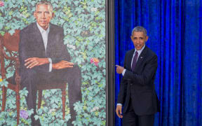 Former US President Barack Obama stands before his portrait by artist Kehinde Wiley after its unveiling at the Smithsonian's National Portrait Gallery.