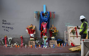A construction worker takes a photo of a memorial, on Bourbon Street in the French Quarter of New Orleans, on 3 January, 2025.