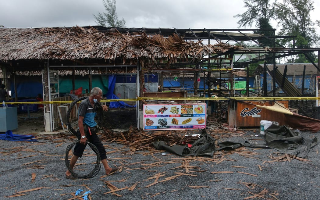 A man walks past the site of a small bomb blast and arson attack on Bang Niang market, Takua Pa, near Khao Lak in Phang Nga province, Thailand.