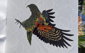 Mosaic artwork of kea on a white background of stylised clouds