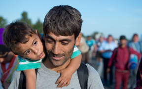 Hundreds of refugees from Syria, Iraq and Africa walk along the motorway towards the Austrian border.