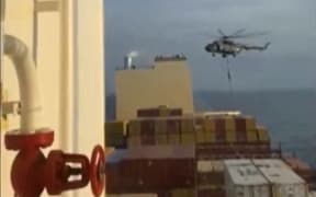 This image grab taken from a UGC video posted on social media on April 13, 2023, shows Iran's Revolutionary Guards rappelling down onto a container ship named, MSC Aries, near the Strait of Hormuz. Iran's Revolutionary Guards on Saturday seized a container ship "related to the Zionist regime (Israel) in the Gulf," state media reported, as tensions soar in the region. (Photo by AFP) / XGTY/RESTRICTED TO EDITORIAL USE - MANDATORY CREDIT AFP -  SOURCE: ANONYMOUS - NO MARKETING - NO ADVERTISING CAMPAIGNS -  DISTRIBUTED AS A SERVICE TO CLIENTS - NO ARCHIVE - AFP IS NOT RESPONSIBLE FOR ANY DIGITAL ALTERATIONS TO THE PICTURE'S EDITORIAL CONTENT /
