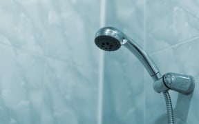 Shower in the bathroom. With water. Selective focus. Blue toned.