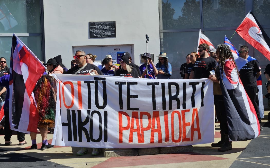 Toitū te Tiriti supporters carry a banner through the Square in Palmerston North.