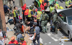 Emergency services assist victims after a car ploughed into them, killing one woman and injuring 19 others