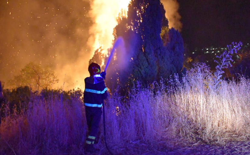 An image taken by Italian Firefighters "Vigili del Fuoco" shows a firefighter combating the fire raging around Palermo, Sicily, that has forced people from their homes, 10  August, 2021.