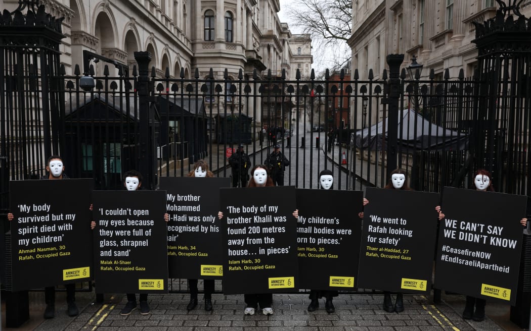 Activists from Amnesty International hold placards with statements made by civilians living in Rafah, in Gaza, during a silent vigil outside the gates of Downing Steet in central London, on February 14, 2024.