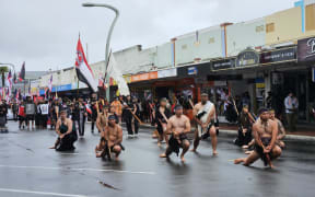 Protestors perform a wero (challenge) while marching through Hastings as part of Hīkoi mō Toitū Te Tiriti.