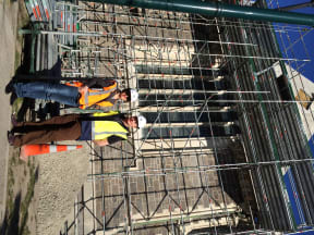 A photo of Pauline Scanlan and Andre Lovatt outside the scaffold-covered Arts Centre