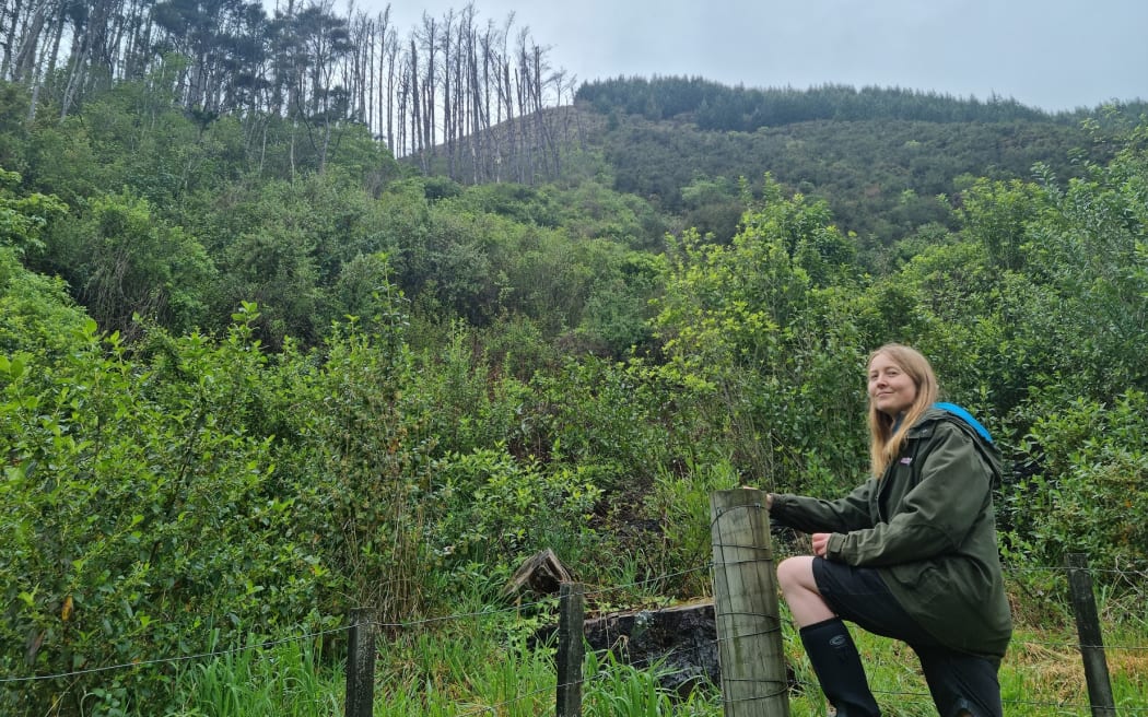 The Brook resident Jen Lang at the boundary of her property with dead pines visible on council land.