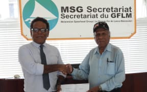 The acting Director-General of the Melanesian Spearhead Group, George Hoa'au (left) receives a contribution to the MSG Secretariat from the ULMWP representative Freddie Waromi.
