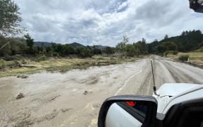 Crews worked to restore a cable which was torn from a bridge near Tologa Bay by the swollen Hikuwai River after Cyclone Hale.