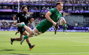 Ireland’s Zac Ward scores against New Zealand.