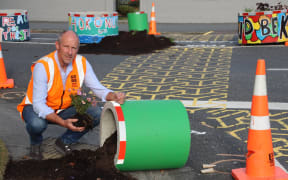 en7Streets.Jpg Up
turned...Gore District 
Council roading manager 
Peter Standring rescues 
plants that were buried in 
soil when a planter pot 
was overturned on the 
corner of Ardwick and 
Preston streets on 
Monday night.