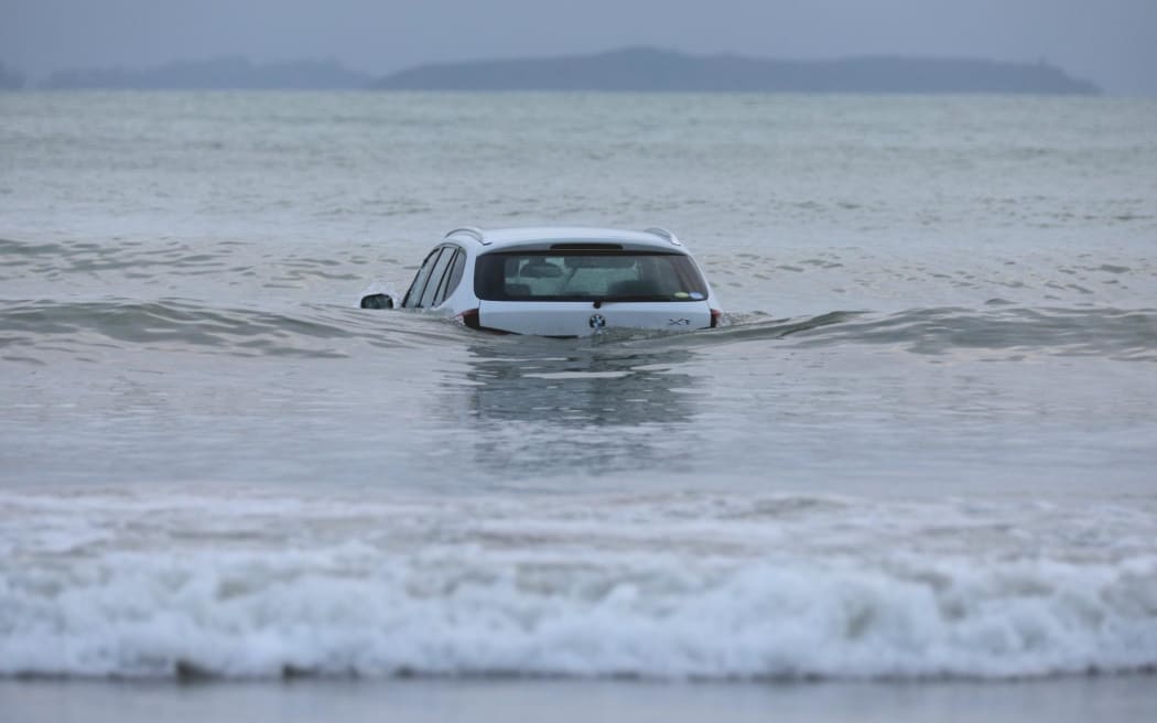 A car in the water at Stanmore Bay, Whangaparāoa Peninsula.