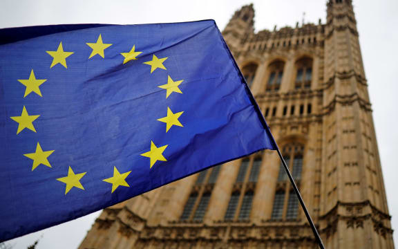 A European Union flag and belonging to an anti-Brexit activist flies outside the Houses of Parliament in London on October 23, 2019.
