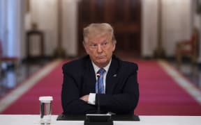 US President Donald Trump sits with his arms crossed during a roundtable discussion on the Safe Reopening of Americas Schools during the coronavirus pandemic, in the East Room of the White House on July 7, 2020, in Washington, DC. (Photo by JIM WATSON / AFP)