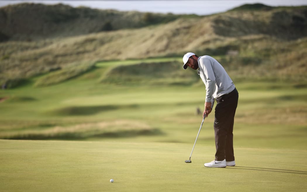 US golfer Scottie Scheffler makes a birdie putt on the 16th green on day two of the 153rd Open Championship at Royal Portrush golf club in Northern Ireland on July 18, 2025. (Photo by HENRY NICHOLLS / AFP) / RESTRICTED TO EDITORIAL USE