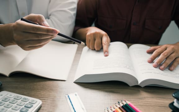 Teenager studying at desk and doing homeworks