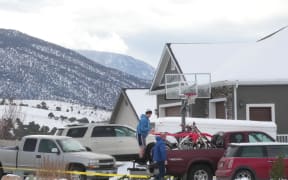 Next door neighbors load up motorcycles into a truck next to the home of Michael Haight on 5 January, 2023 in Enoch, Utah.