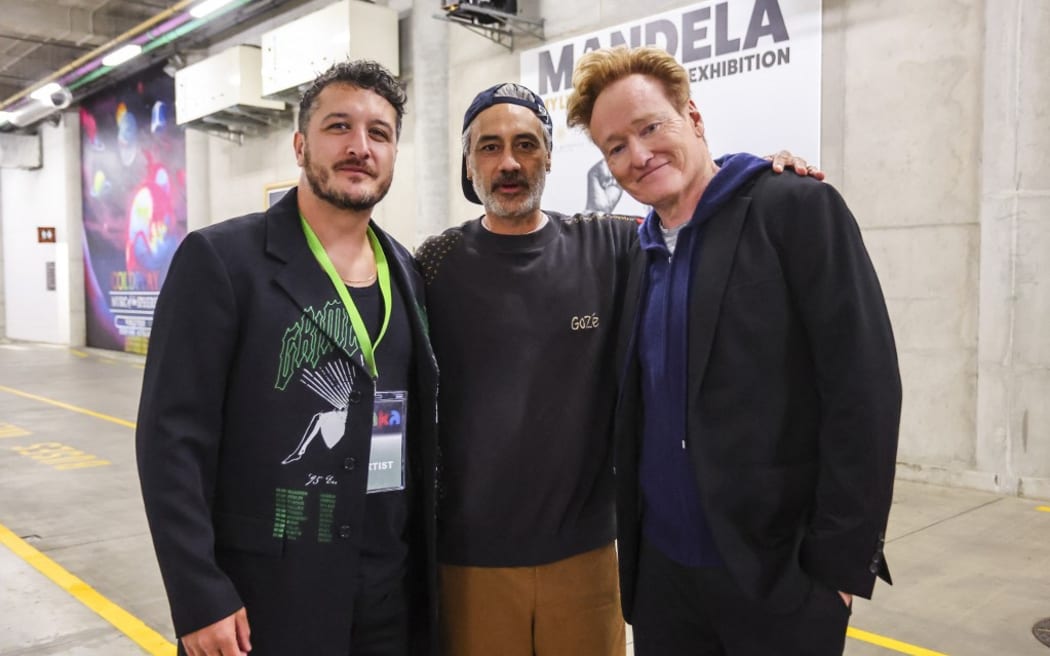 From L-R: Matiu Walters, frontman of the New Zealand band Six60, New Zealand filmmaker-actor Taika Waititi, and US comedian and television personality Conan O’Brien pose ahead of a world record attempt for the largest mass Haka, at Eden Park in Auckland on September 29, 2024. Organisers hope a crowd of up to 10,000 will smash the previous record, officially held by France since 2014, of the Maori war dance made famous by the All Blacks. (Photo by DJ Mills / AFP)