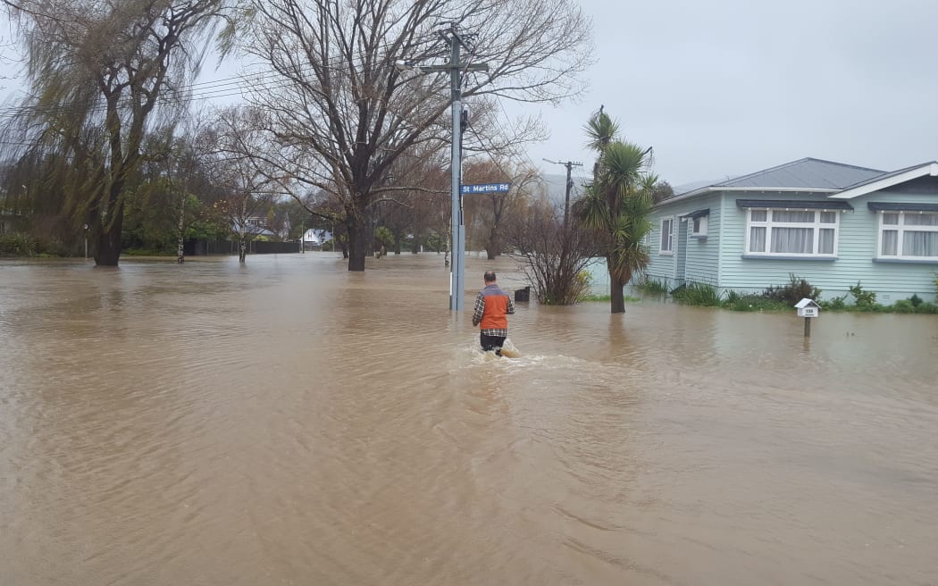 Duane Burgess heads back into the floodwaters to deliver some medication to a friend, whose house on Riverlaw Terrace is now surrounded with water.