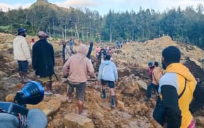 People gather at the site of a landslide in Maip Mulitaka in Papua New Guinea's Enga Province on May 24, 2024. Local officials and aid groups said a massive landslide struck a village in Papua New Guinea's highlands on May 24, with many feared dead. (Photo by AFP)