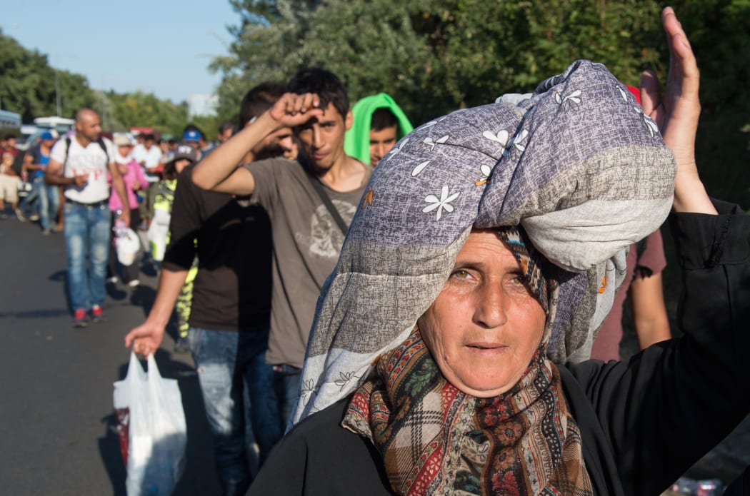 Amina Hmeid - from Deraa in Syria - carries her possessions on her head, as she and hundreds of other refugees and migrants attempt to walk to Austria.