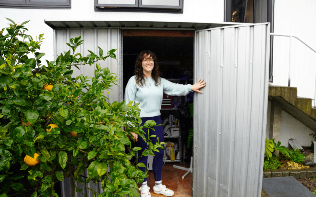 Image of a woman holding open a shed door