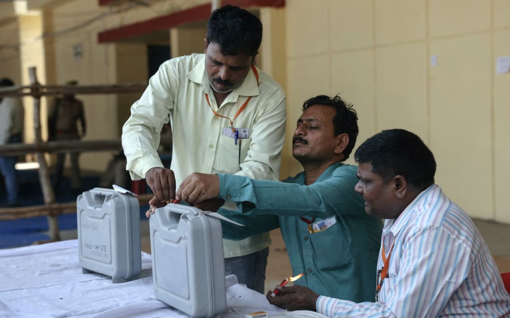 Electoral officials seal an Electronic Voting Machine (EVM) after the counting at an election vote counting centre in Varanasi on June 4, 2024. Vote counting began in India's election on June 4, with Prime Minister Narendra Modi all but assured a triumph for his Hindu nationalist drive that has thrown the opposition into disarray and deepened concerns for minority rights. (Photo by Niharika KULKARNI / AFP)