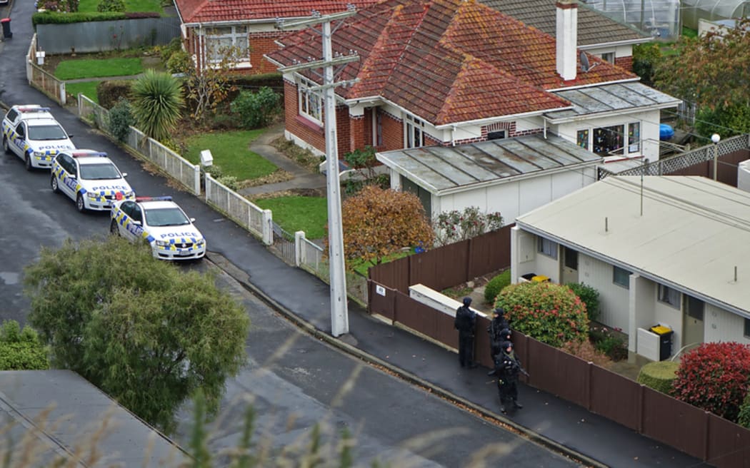 Armed offenders squad members search a Dunedin street.