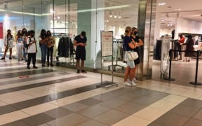 People wait to enter a store in a shopping mall as stores limit the number of customers allowed inside during the novel coronavirus (COVID-19) pandemic in Toronto, Ontario, Canada on July 03, 2021. Ontario is now in the second stage of the 3 stage reopening plan.