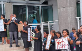 Aggrieved employees of the university showed up dressed in black, holding placards calling for “fair pay” and for Ahluwalia to resign.