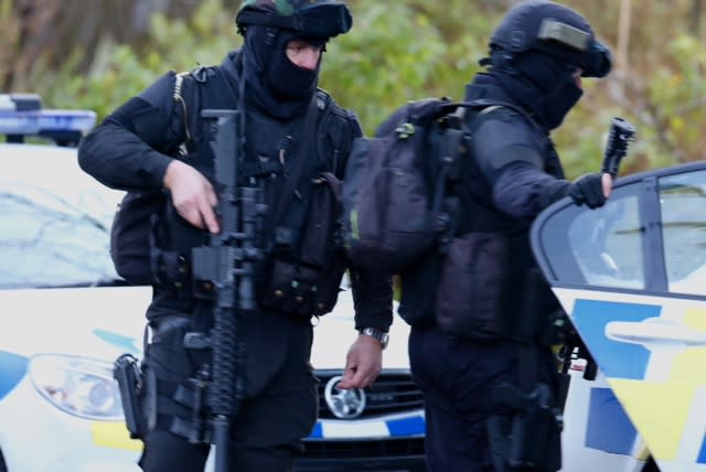 Armed police officers leave an address in Ohakune during the search.