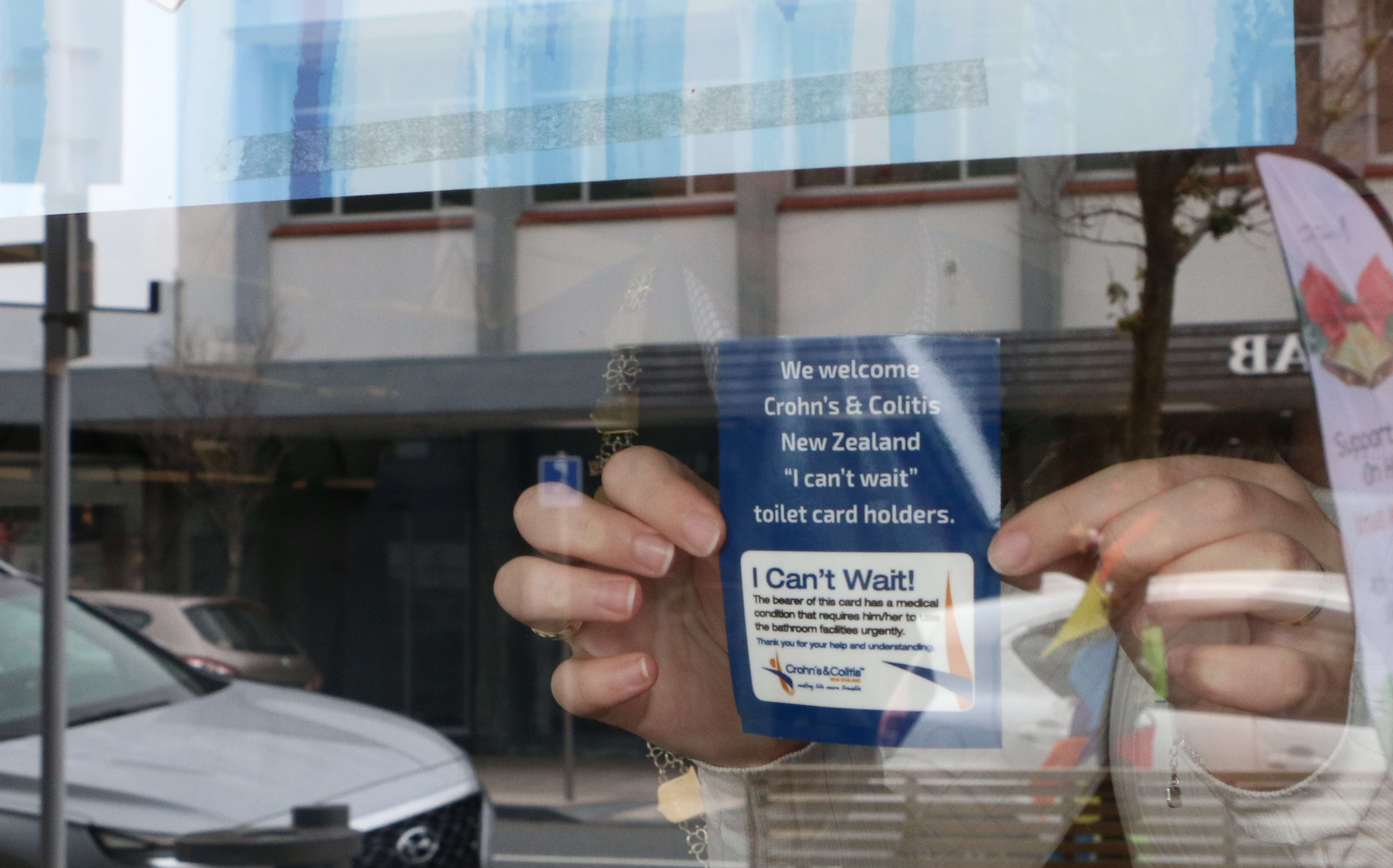 A sticker in the window of Atrium Cafe, Lower Hutt to let people with bowel disease use their toilets.