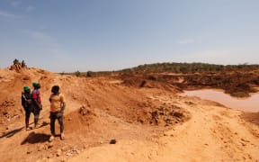 People look at an artisanal gold mine in Danga on January 31, 2025, the following day after a landslide killed at least 10 people and left many others missing. (Photo by OUSMANE MAKAVELI / AFP)