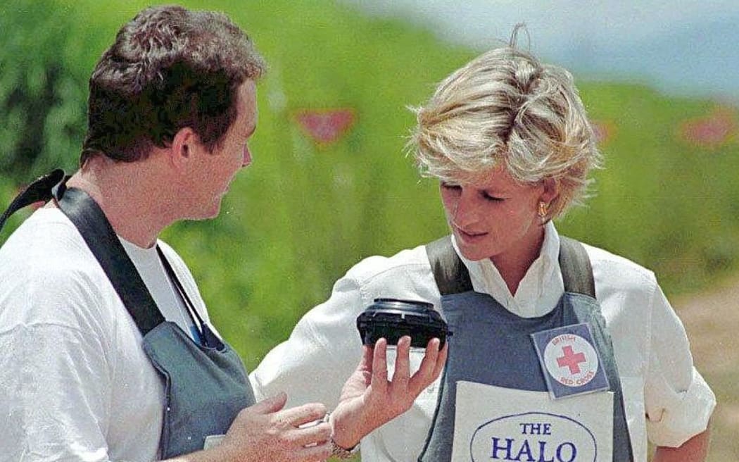 Britain's Princess Diana, wearing a heavy duty protection vest, is accompanied 15 January by a mine clearing expert of the Halo Trust during her visit to the minefields in the high plateaux near Huambo, to watch mine-clearing operations in an area once on the frontline of the country's civil war.