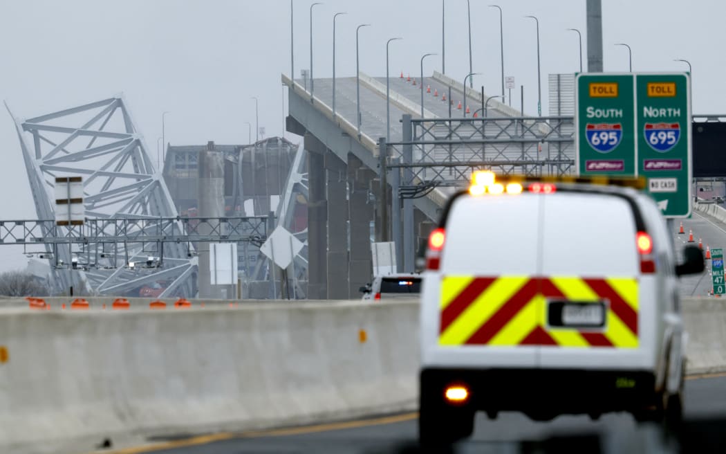BALTIMORE, MARYLAND - MARCH 27: The collapsed Francis Scott Key Bridge is seen in the background of the on ramp to the bridge on March 27, 2024 in Baltimore, Maryland. Two survivors were pulled from the Patapsco River and six missing people are presumed dead after the Coast Guard called off rescue efforts. A work crew was fixing potholes on the bridge, which is used by roughly 30,000 people each day, when the ship struck at around 1:30am on Tuesday morning. The accident has temporarily closed the Port of Baltimore, one of the largest and busiest on the East Coast of the U.S.   Anna Moneymaker/Getty Images/AFP (Photo by Anna Moneymaker / GETTY IMAGES NORTH AMERICA / Getty Images via AFP)