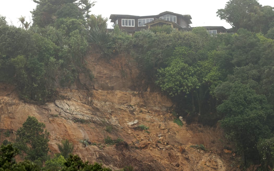AUCKLAND, NEW ZEALAND - FEBRUARY 14: A large landslide threatens houses in the coastal suburb of Muriwai following Cyclone Gabrielle on February 14, 2023 in Auckland, New Zealand. New Zealand has declared a national state of emergency with flooding and landslides devastating several communities. (Photo by Phil Walter/Getty Images)