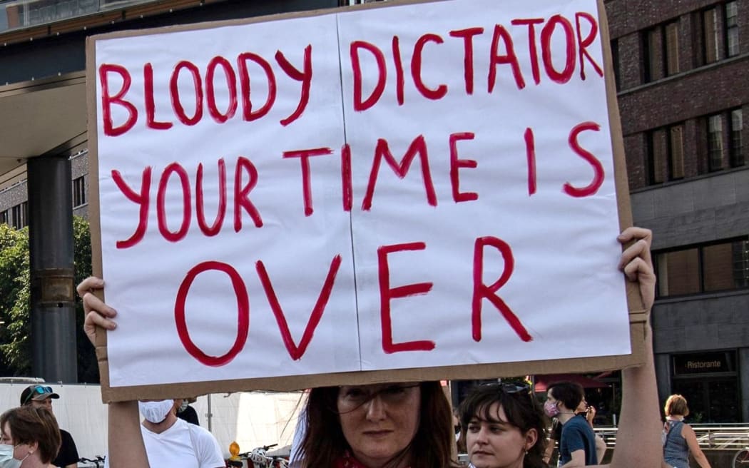 15 August 2020, Berlin: A demonstrator is standing on Potsdamer Platz with a poster saying "Bloody Dictator, your time is over".