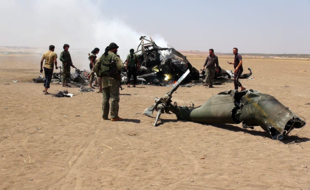 A photo taken on 1 August, 2016 reportedly shows Syrian rebels gathered round the wreckage of a downed Russian military helicopter.