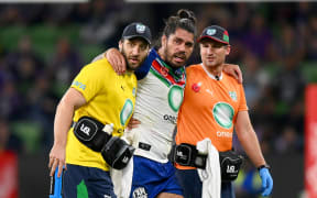 Tohu Harris of the Warriors is helped from the field with an injury.