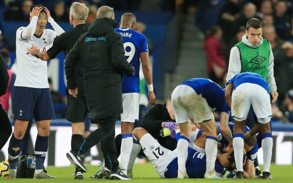 Son Heung-Min of Spurs is inconsolable as Andre Gomes of Everton lies injured.