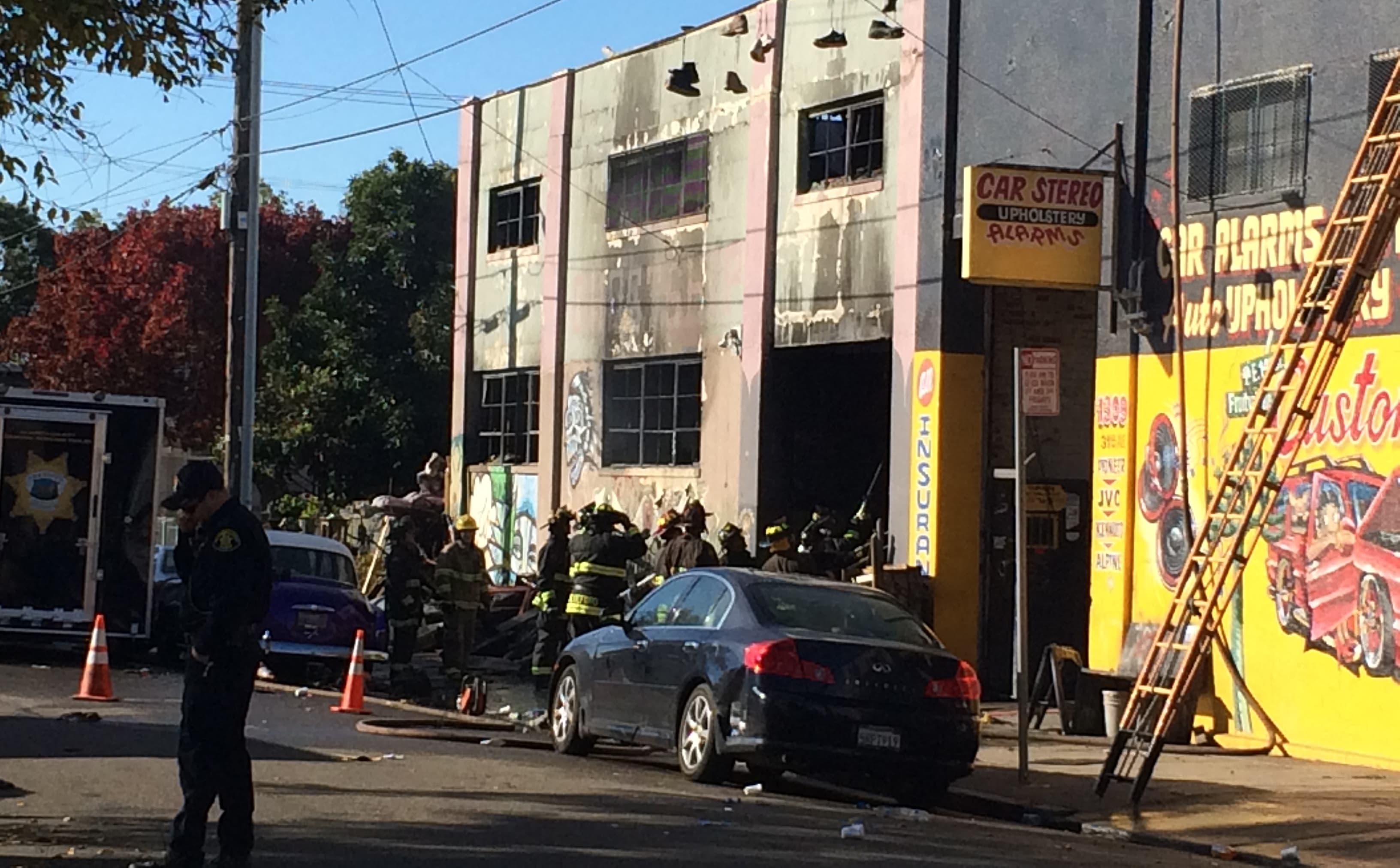 Firefighters inspect the warehouse in the Fruitvale district after the fire which killed at least nine people.
