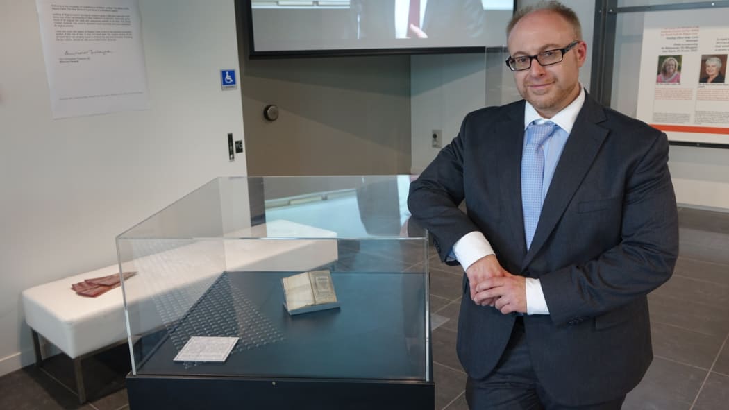 Lead curator and UC historian Dr Chris Jones, Dr Chris Jones standing next to the display cabinet of the Magna Carter.