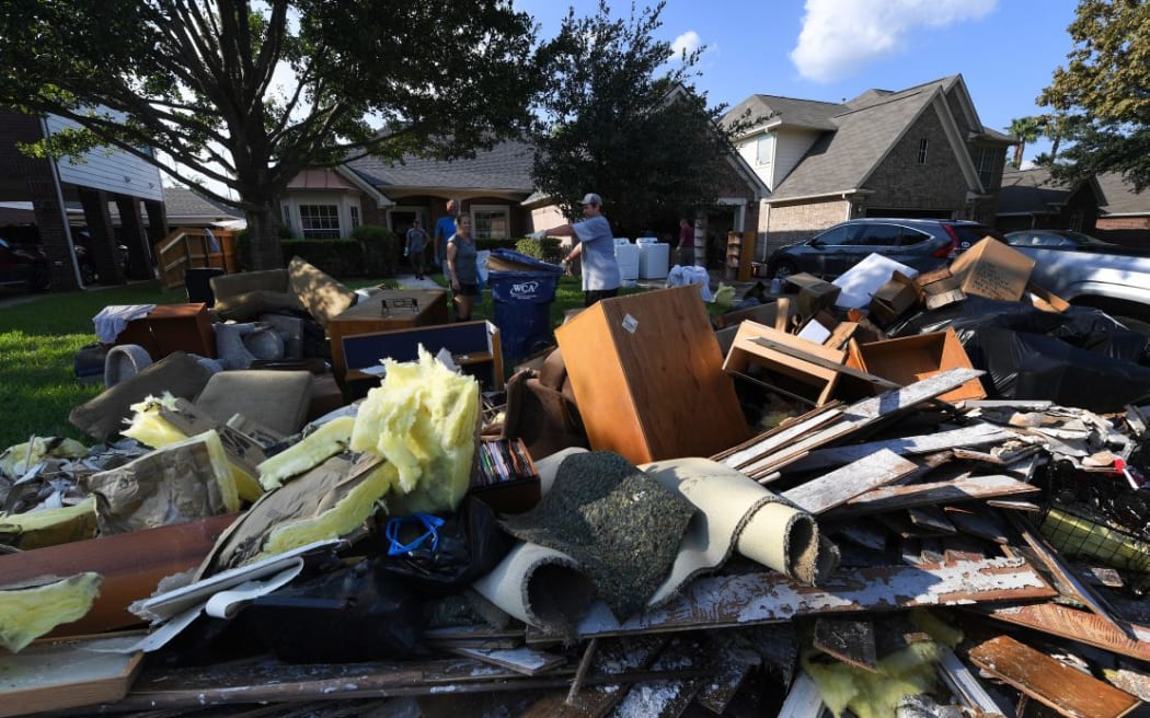 Members of the Olson family remove debris and damaged items from their father's home in the Twin Oaks Estate after flooding caused by Hurricane Harvey.