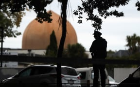 An armed policeman stands guard in front of the Masjid Al Noor Mosque in Christchurch on March 16, 2019. (Photo by MICHAEL BRADLEY / AFP)