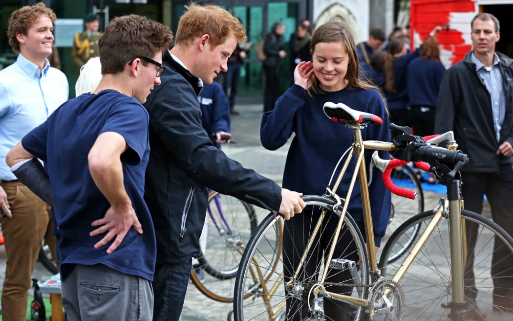Prince Harry checks out his new bike, gifted by the Student Volunteer Army.