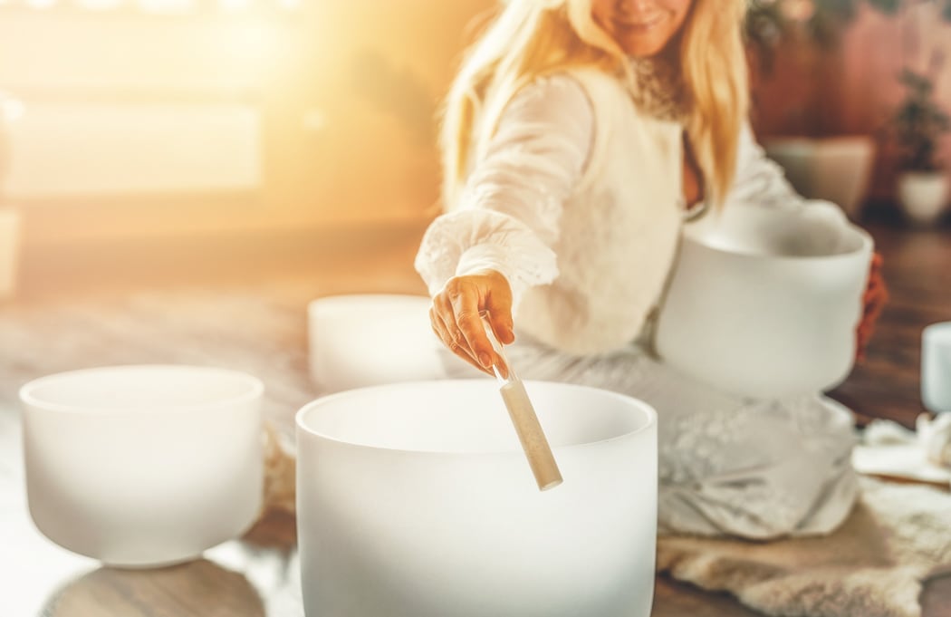 Woman playing with crystal bowl.